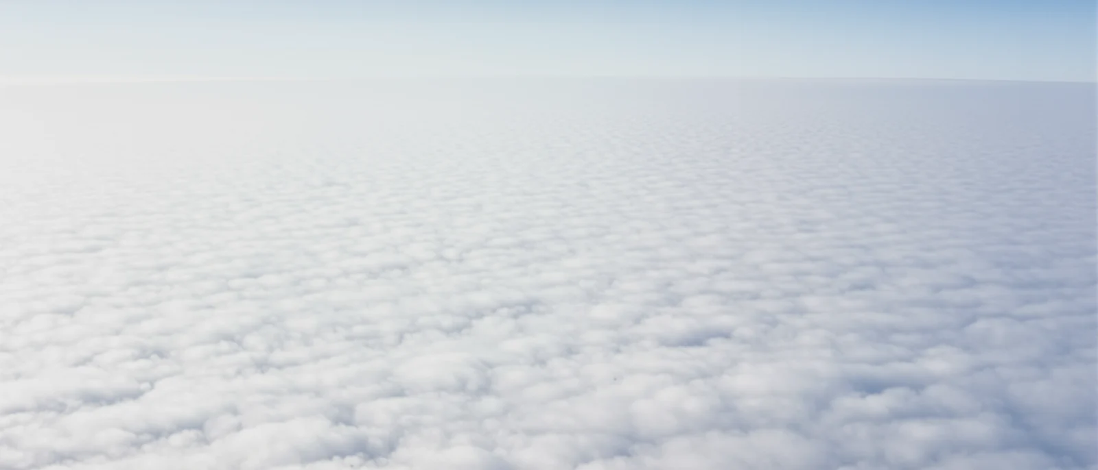An endless layer of soft white clouds seen from high altitude